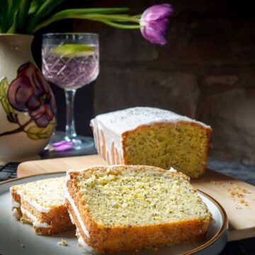 pink gin and poppy seed cake with glass of pink gin in back ground