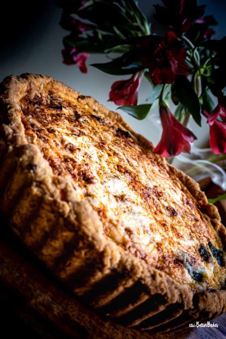 vegetable quiche on a slant with flowers