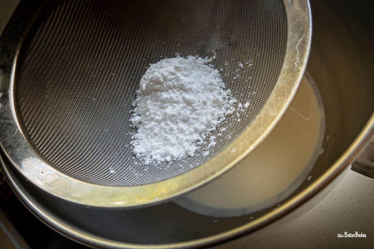 icing sugar being sifted into double cream