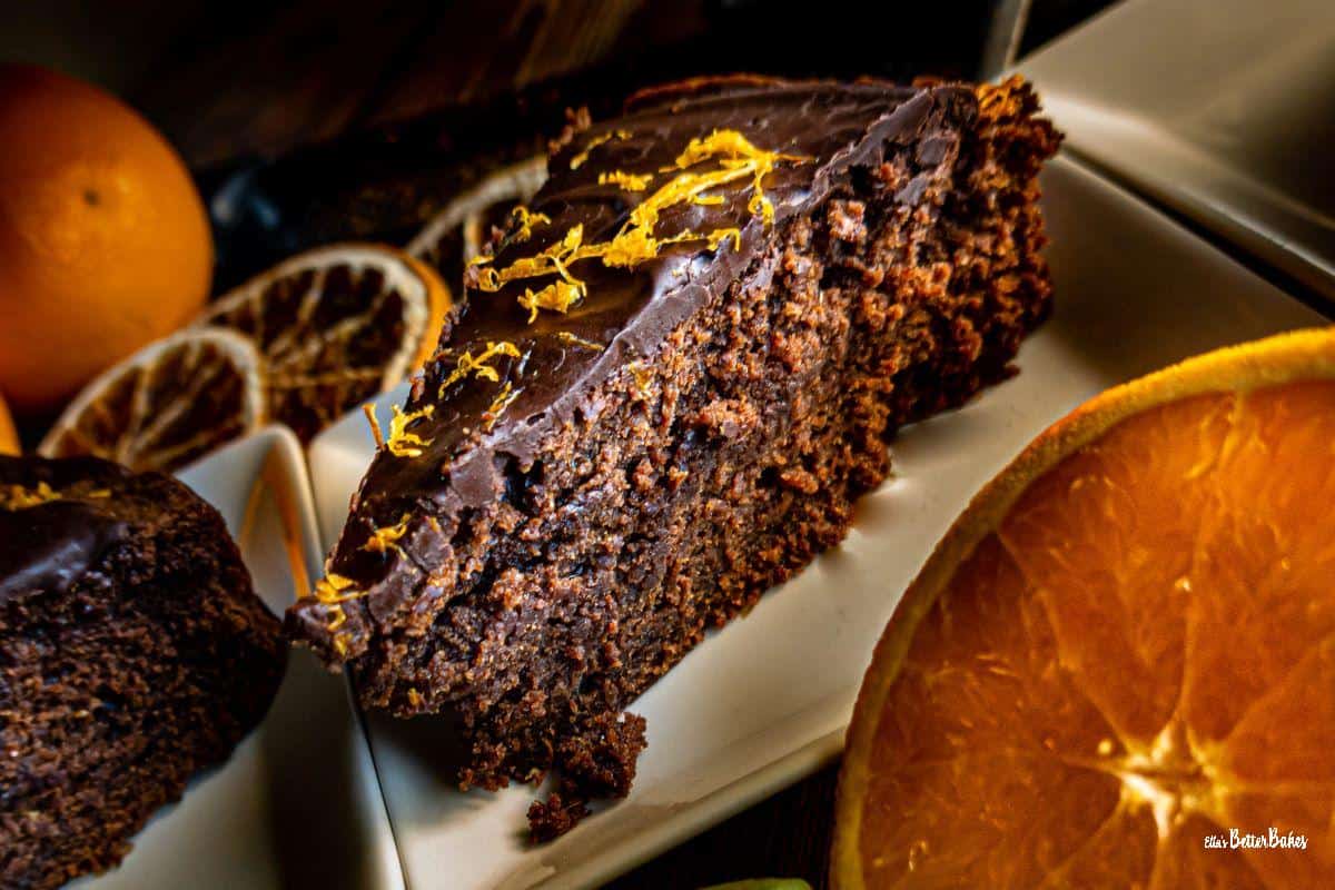 slice of a piece of chocolate orange cake next to an orange