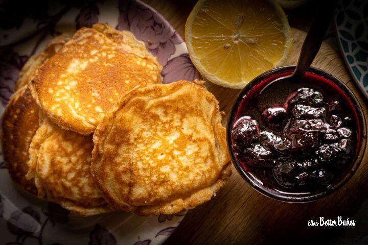 lemon pancakes next to bowl of cherry syrup