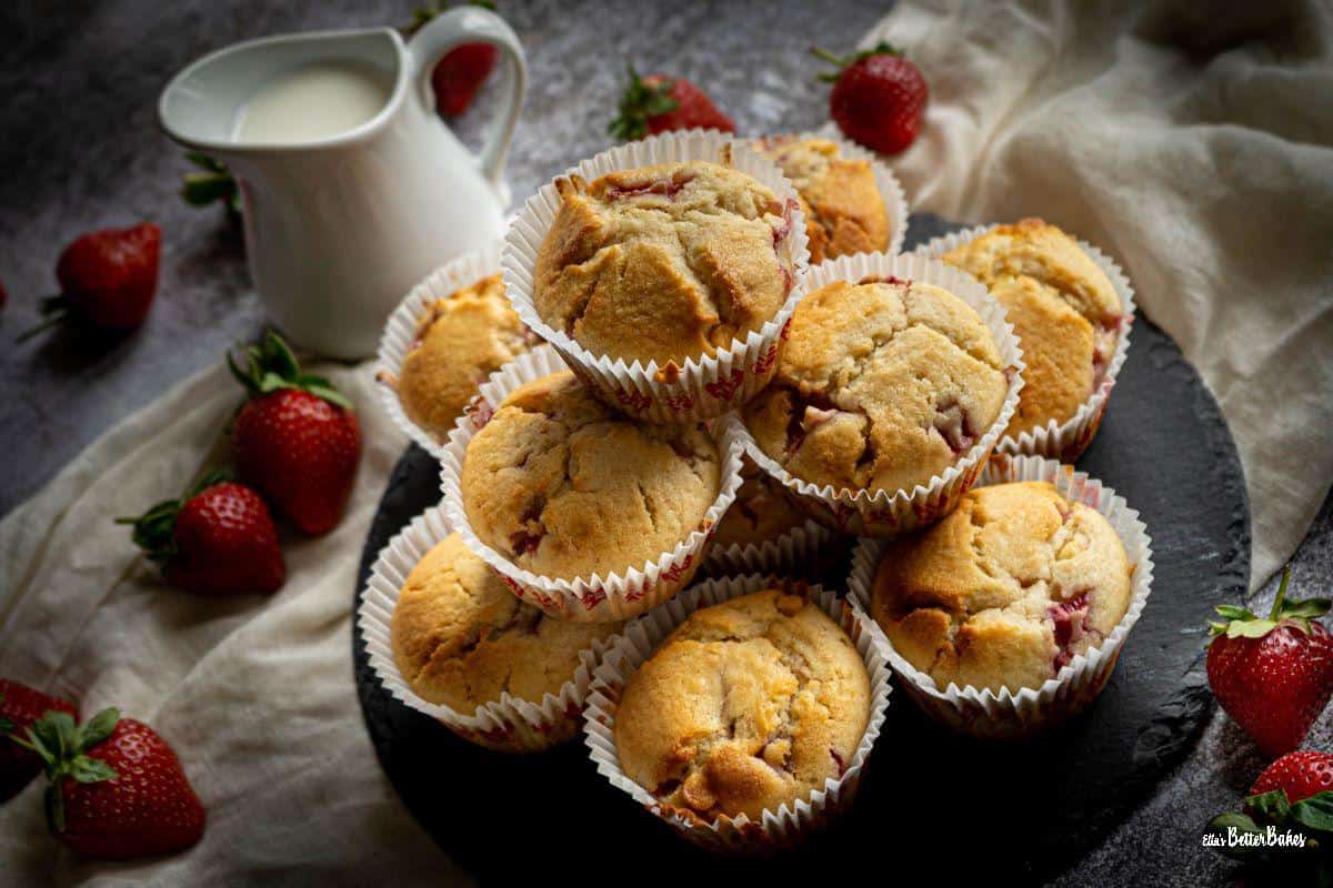 strawberry and white chocolate muffins on a grey slated next to strawberries