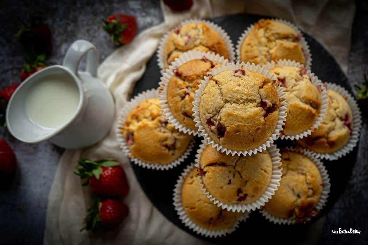 strawberry and white chocolate muffins top shot next to milk and strawberries