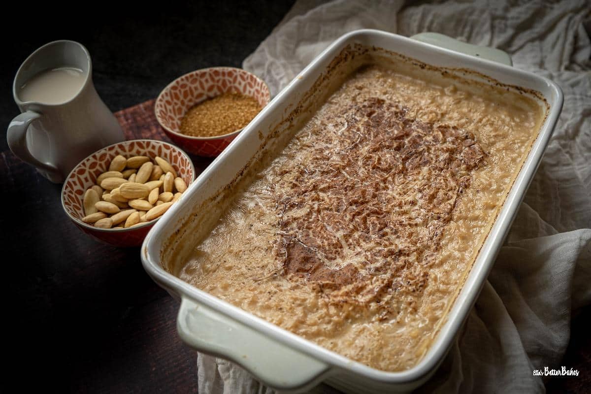 almond milk rice pudding next to bowls of almonds and sugar