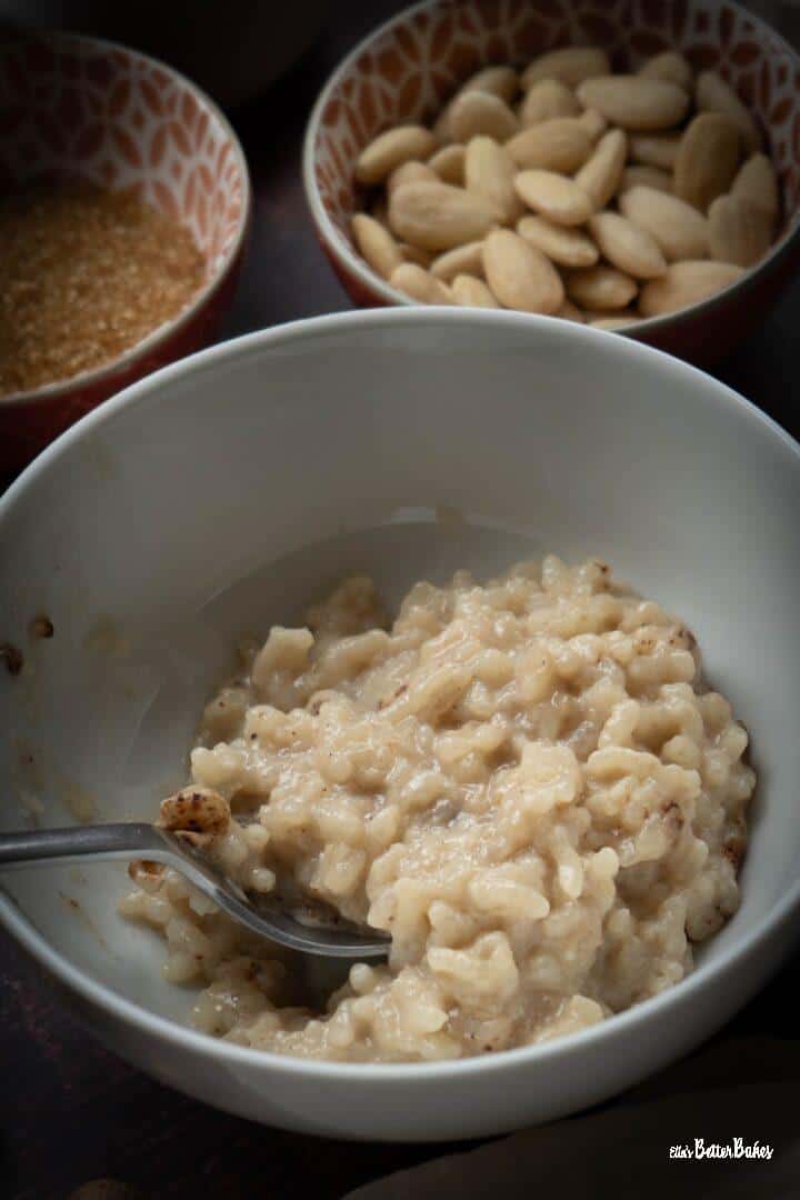 portrait sized picture of almond milk rice pudding next to almonds