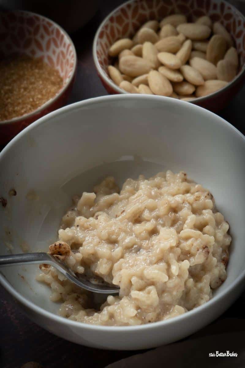 portrait sized picture of almond milk rice pudding next to almonds