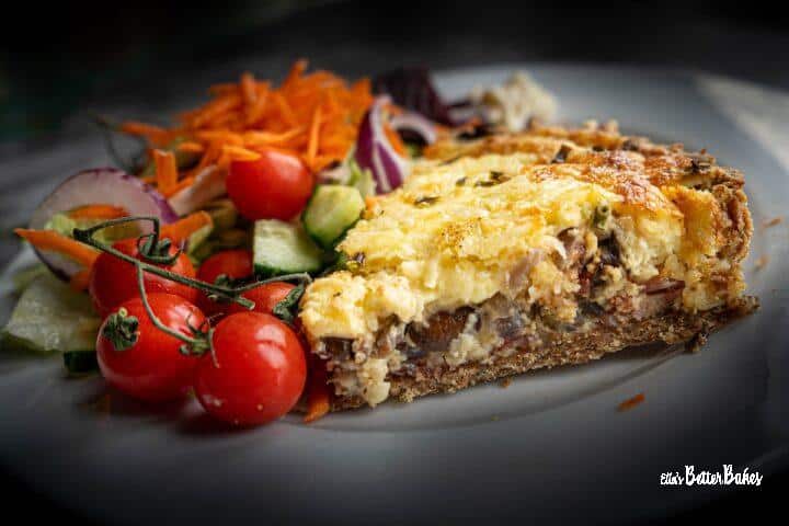Bacon and Mushroom Quiche on a plate next to salad