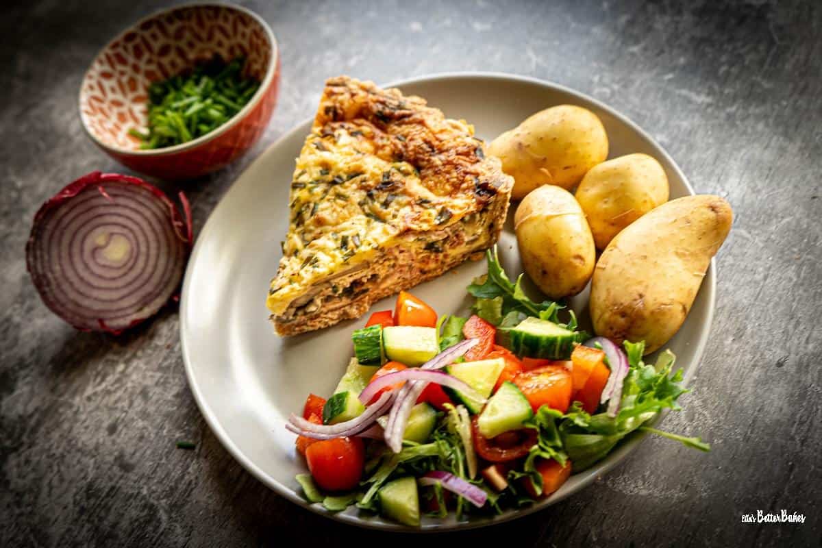 mushroom and bacon quiche on a plate with salad