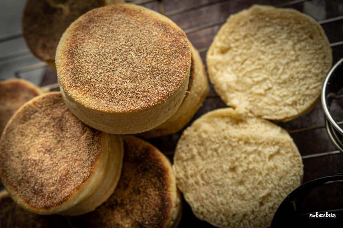 stack of sourdough muffins next to a cut muffin