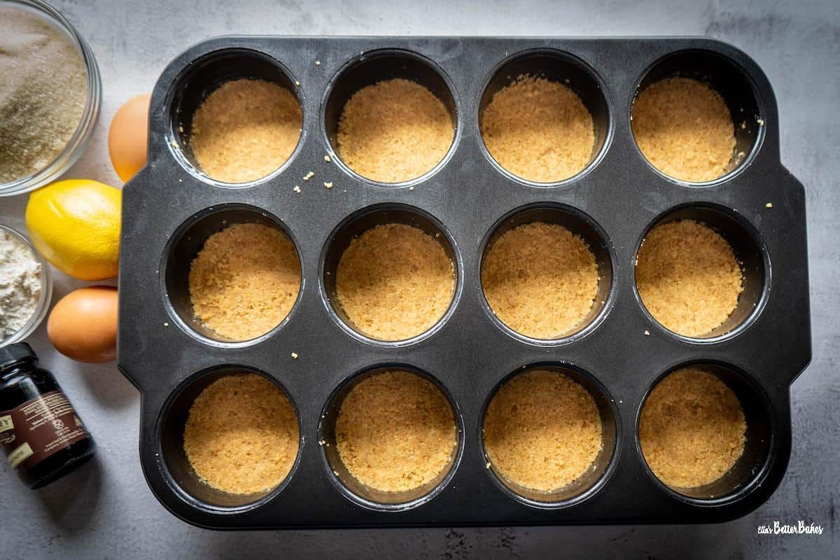 biscuit base fullly pressed inot each cheesecake tin hole