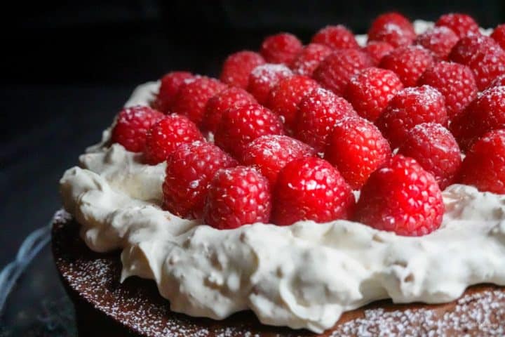 close up raspberries on cake